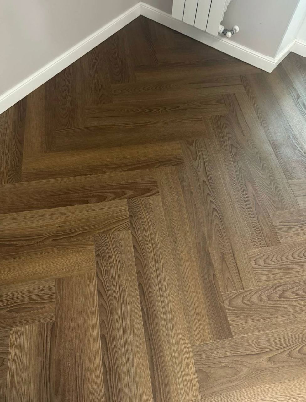 Кварцвиниловый SPC ламинат Vinilam Parquet Herringbone Паркет Винсент IS11200 венгерская елка 720×120×6,5 фото в интерьере